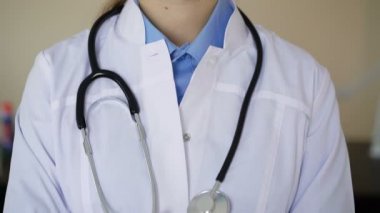 Kameraya bakarak yüz maskesi giyen kadın tıbbi işçi