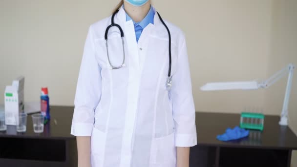 Trabalhadora médica usando máscara facial olhando para a câmera — Vídeo de Stock