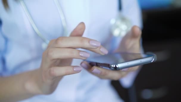 Terapeuta femenina usando smartphone, deslizamiento, desplazamiento, zoom en la pantalla táctil — Vídeos de Stock