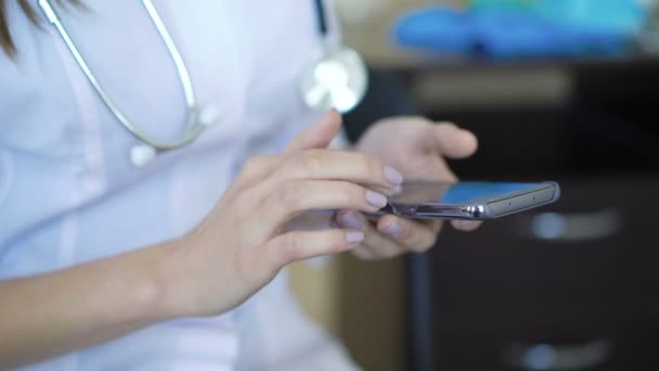 Жінка-терапевт використовує смартфон, ковзає, прокручує, збільшує масштаб на сенсорному екрані — стокове відео