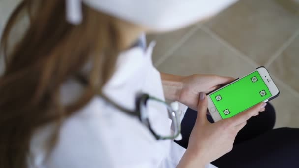 Doctora mostrando teléfono inteligente con pantalla verde — Vídeos de Stock