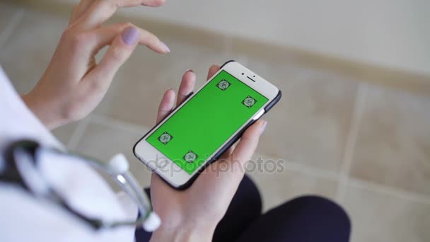 Doctora mostrando teléfono inteligente con pantalla verde — Vídeos de Stock