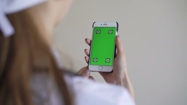 Doctora mostrando teléfono inteligente con pantalla verde — Vídeo de stock