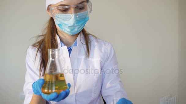 Jeune chimiste femme faisant des expériences scientifiques avec des produits chimiques — Video