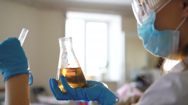 Молода жінка-хімік проводить науковий експеримент з хімікатами — стокове відео