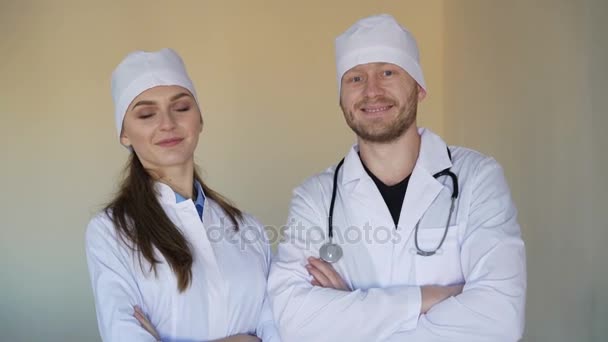 Young female doctor and a male doctor looking at the camera and smiling, 4k. — Stock Video