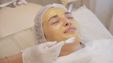 Yüzünde model altın maskesi uygulama. Yakın çekim