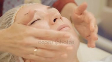 Yüzünde krem uygulamak ve güzellik salonunda Masaj