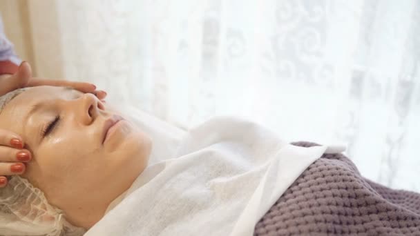 Aplicação de creme no rosto e massagem no salão de beleza — Vídeo de Stock