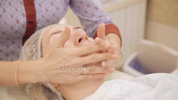 Aplicação de creme no rosto e massagem no salão de beleza — Vídeo de Stock