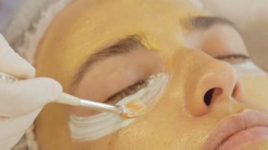 Yüzünde model altın maskesi uygulama. Yakın çekim