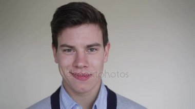 Ciddi görünümlü kameraya ve 4 k'dan fazla gülümseyen genç adam