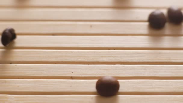 Pražená kávová zrna, dopadající na na povrchu stolu v rozlišení 4k — Stock video