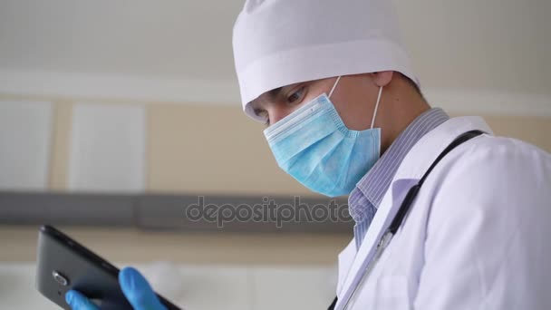 Чоловік лікар працює на планшеті в лікарні в 4K — стокове відео