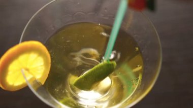 Alkol arka planda limonlu kadehi karıştırma. Yavaş yavaş