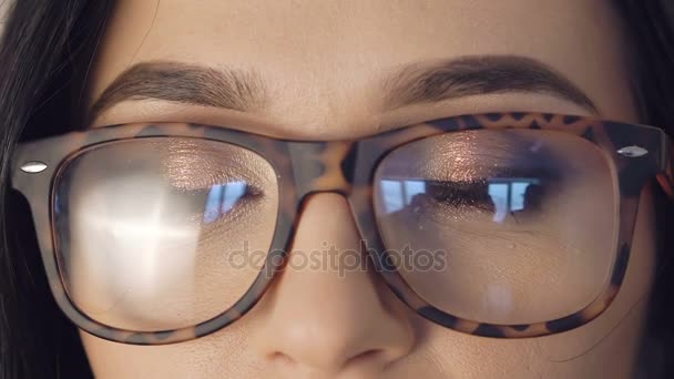 Detail dívky očí otevření a při pohledu do kamery v brýlích