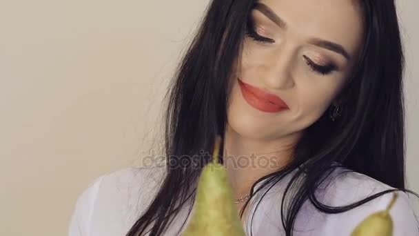 Όμορφο κορίτσι χαμογελά και ποζάρει με δύο μεγάλα ζουμερά αχλάδια πράσινα. — Αρχείο Βίντεο