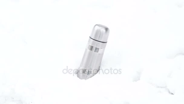 Thermoskanne liegt im Schnee auf weißem Hintergrund — Stockvideo