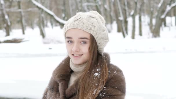 Ziemlich glückliches Mädchen, das im Wintertag in Pose steht und in die Kamera blickt. langsam — Stockvideo