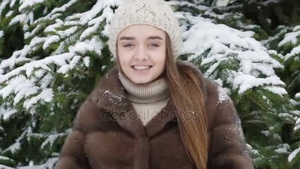 Un trozo de nieve cayendo sobre la chica de pie cerca del árbol. Movimiento lento — Vídeos de Stock