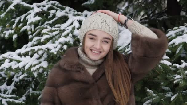 Ένα κομμάτι από το χιόνι που υπάγονται στο κορίτσι στέκεται κοντά στο δέντρο. Αργή κίνηση — Αρχείο Βίντεο