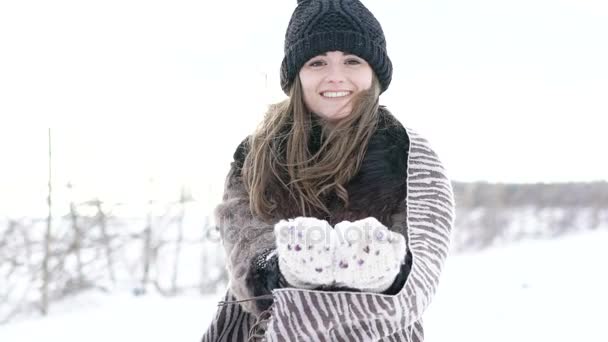 A lány hó hányt, és mosolyogva kamera előtt a téli nap. Lassan — Stock videók