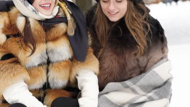 Due ragazze felici che sorridono e vomitano neve nel parco. Lentamente. — Video Stock