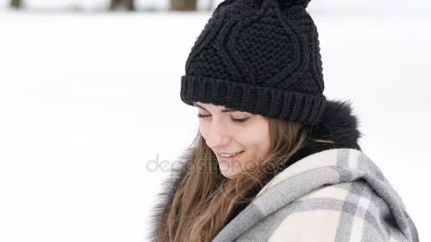 Retrato de una chica bonita sonriendo a la cámara en un día frío y ventoso. Despacio. — Vídeo de stock