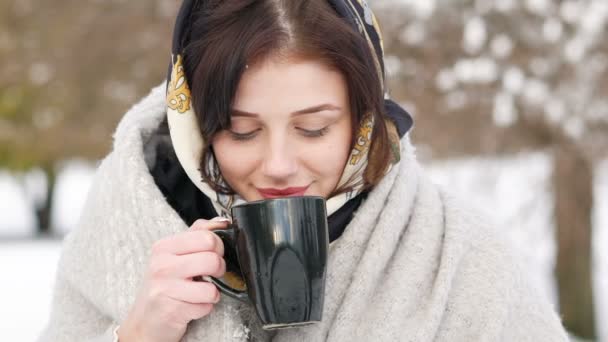 Молодая девушка пьет горячий чай в зимний день. Медленно. — стоковое видео