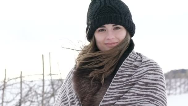 Atraktivní dívka, úsměvu a pohledu do kamery na vítr studený zimní den — Stock video