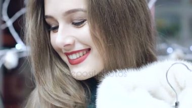 Güzel kız bir kürk manto dükkanda yavaş yavaş seçer