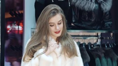 Mutlu kız çalışırken ve kürk manto dükkanda poz. Yavaş yavaş