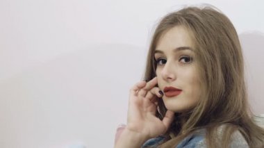 Güzel kız yatak arka plan üzerinde duygularla kamera için poz. Yavaş yavaş