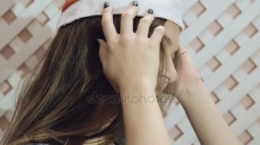 Mutlu kız arka plan üzerinde poz Noel Baba şapkası. Yavaş yavaş