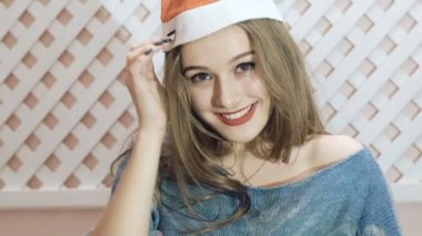 Mutlu kız arka plan üzerinde poz Noel Baba şapkası. Yavaş yavaş