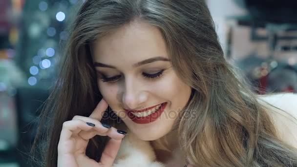 Chica feliz probándose y posando en abrigo de piel en la tienda. Despacio. — Vídeo de stock