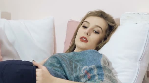 Smart Girl entspannt sich, liegt und posiert auf dem Bett. langsam — Stockvideo