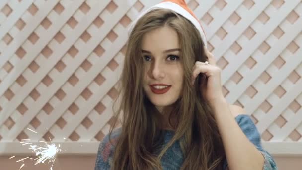 Ragazza felice in cappello di Babbo Natale posa con scintilla in mano Lentamente — Video Stock