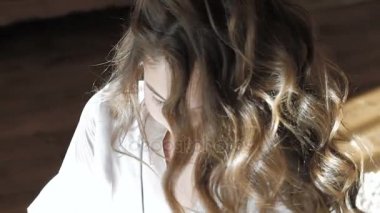 Baştan çıkarıcı kız gülümseyerek, saç atma ve yatağa poz iyi. Yavaş yavaş