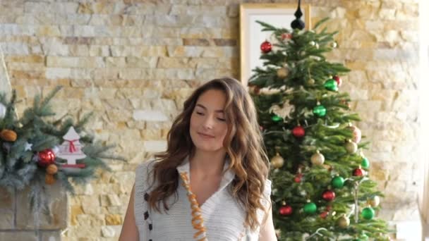 Chica feliz posando, sonriendo a la cámara en la habitación decorada. Despacio. — Vídeos de Stock