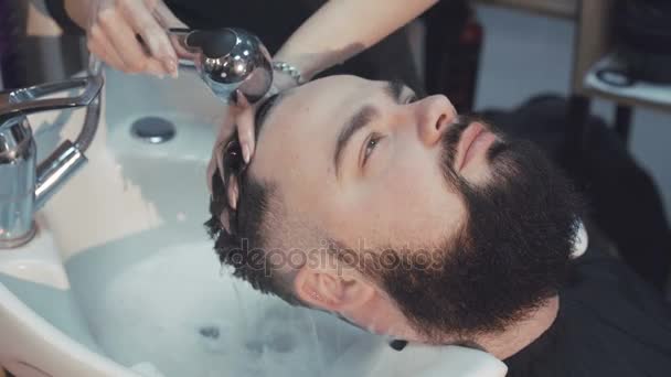 Jonge hipster man met zijn haren gewassen in een kapsalon. 4k — Stockvideo