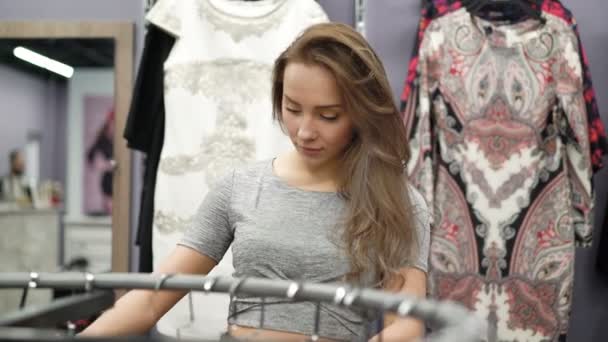 Stylowa dziewczyna patrząc na ubrania w modnym butiku. 4k — Wideo stockowe