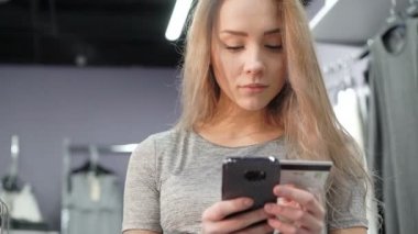 Bir kredi kartı tutan ve online alışveriş için cep telefonunuzun bir kadın. 4k