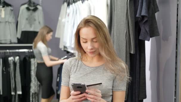 Mulher segurando um cartão de crédito e usando telefone celular para compras on-line. 4K — Vídeo de Stock