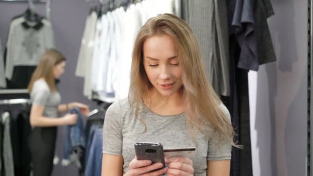 Bir kredi kartı tutan ve online alışveriş için cep telefonunuzun bir kadın. 4k — Stok video