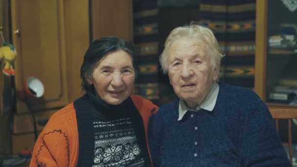 Retrato de duas mulheres sorridentes muito idosas sentadas na mesa de férias. 4K — Vídeo de Stock