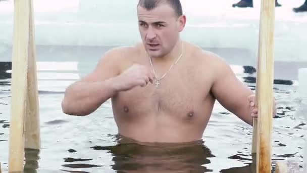 Young man having recreational swim in the ice hole — Stock Video