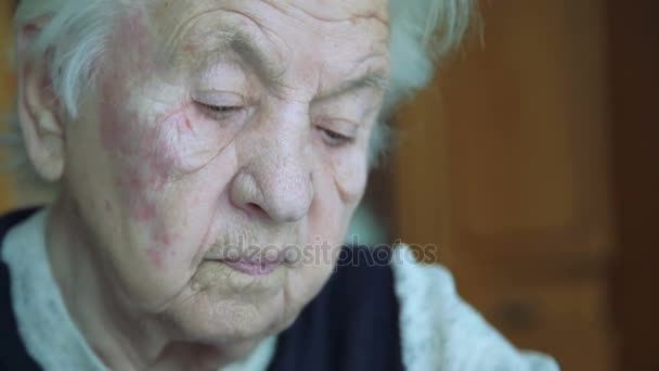 Portrait of old wrinkled tired alone grandmother looking and says at camera