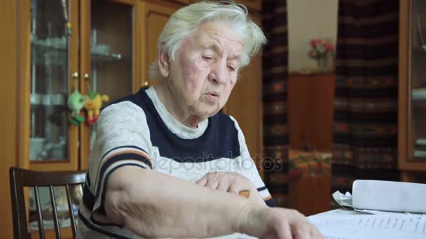 Den gamla kvinnan som arbetar med dokument — Stockvideo