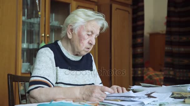 De oude vrouw die met documenten werkt — Stockvideo